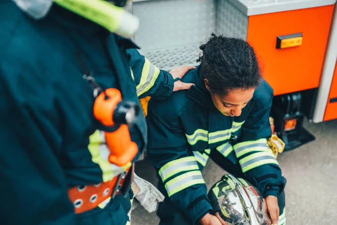 First responder receiving support beside an emergency vehicle
