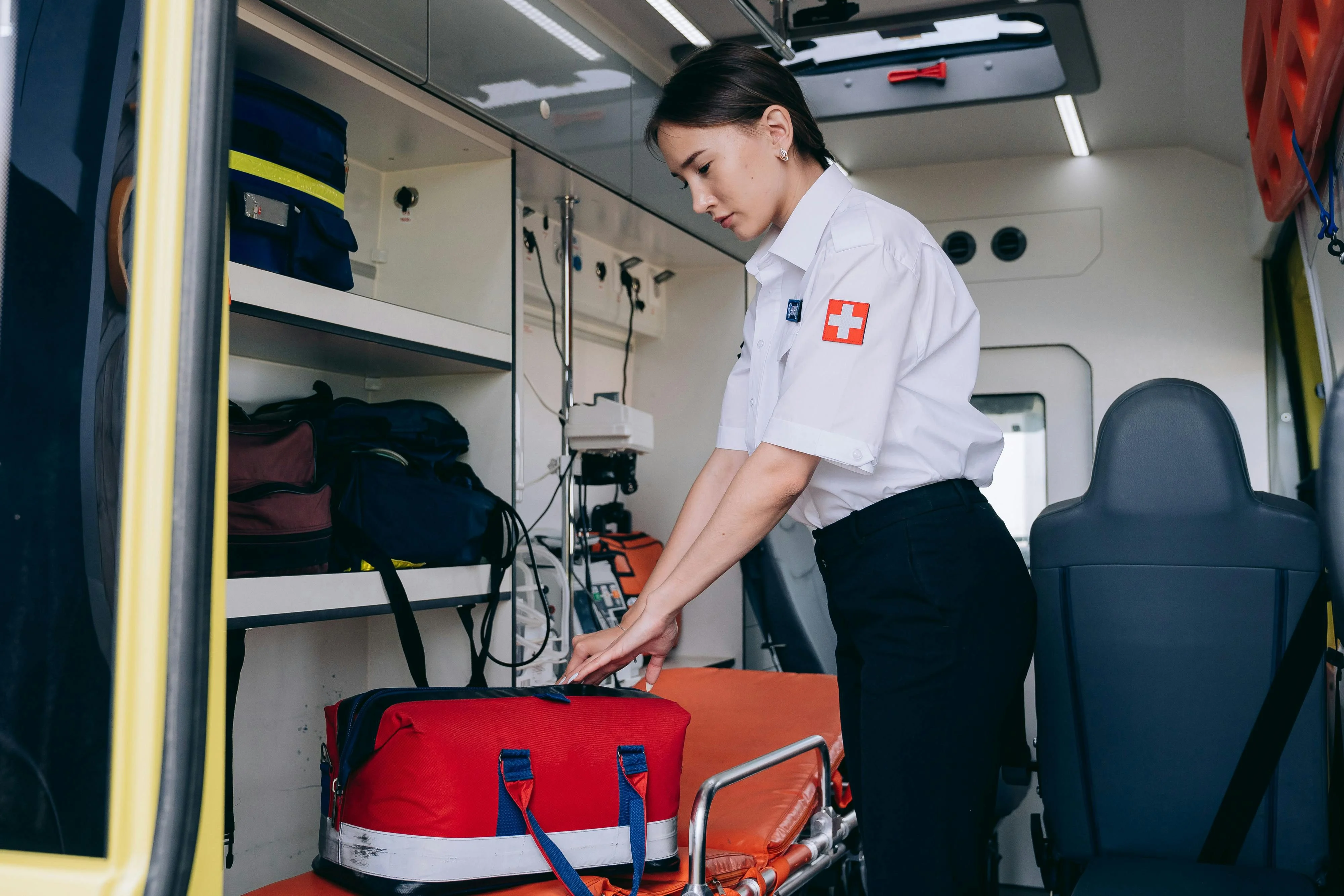 Paramedic preparing equipment inside an ambulance