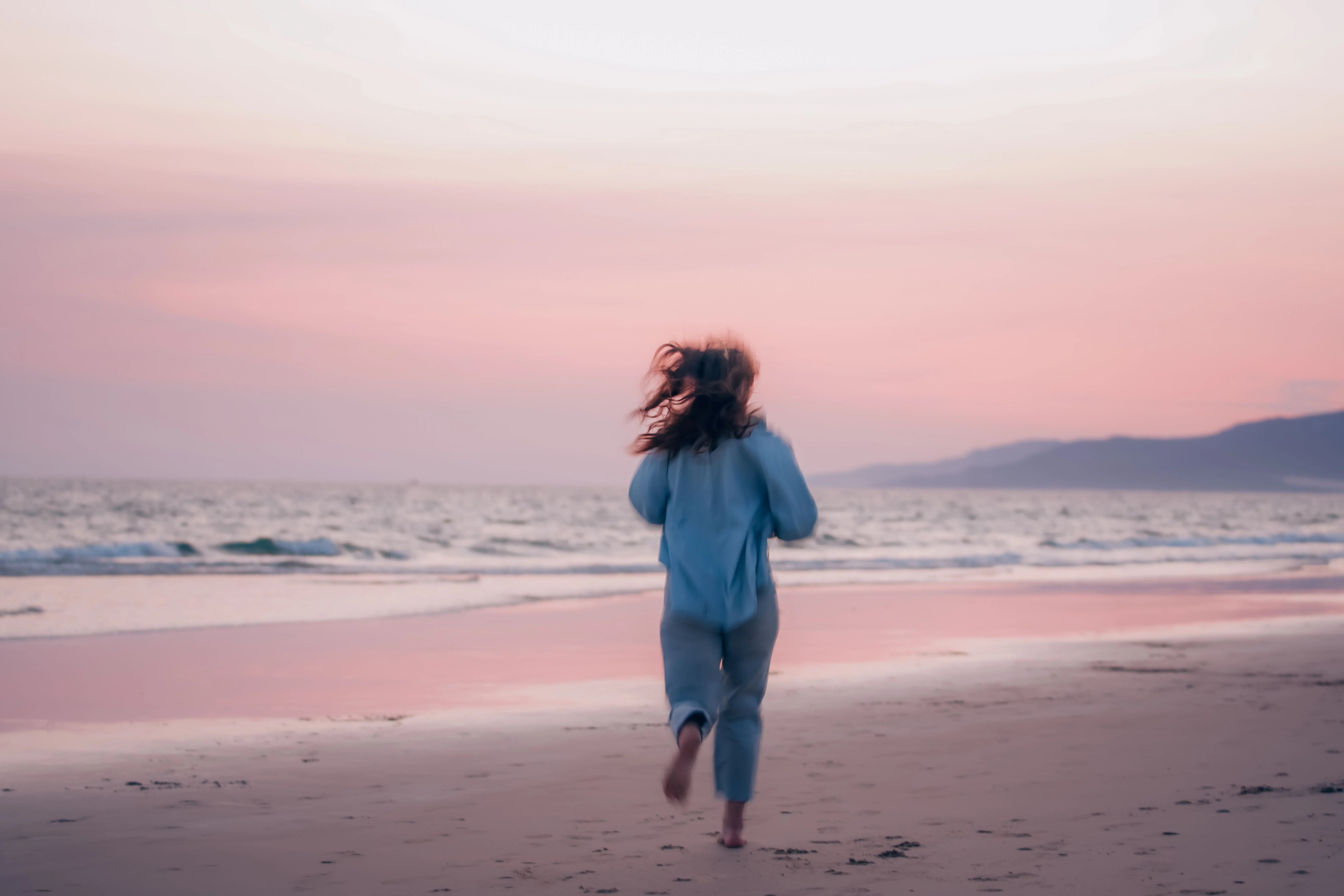 Person walking along the beach at dusk